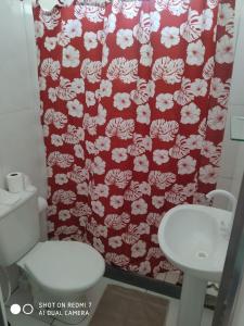 a bathroom with a red shower curtain and a toilet at Jardim Paraíso in Duque de Caxias