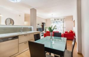 uma cozinha e sala de estar com uma mesa de vidro e cadeiras em Eli Greko Apartament em Chania Town