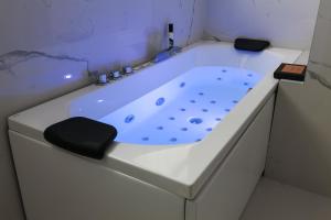 eine weiße Badewanne mit schwarzem Sitz im Bad in der Unterkunft PRESTIGE BOUTIQUE APARTHOTEL -Piazza Duomo in Mailand
