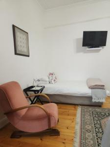 a living room with a chair and a bed at Die Dorpshuis Graaff Reinet in Graaff-Reinet