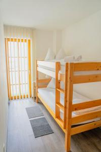 2 Etagenbetten in einem Zimmer mit Fenster in der Unterkunft Modern Mountain Apart 2 - directly by Skiing area in Rauris