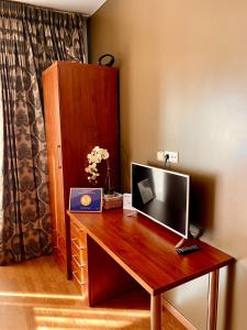 einen hölzernen Schreibtisch mit einem TV darüber in der Unterkunft Chocolate Apart in Druskininkai
