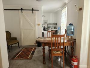 a kitchen with a table and chairs and a barn door at Die Dorpshuis Graaff Reinet in Graaff-Reinet