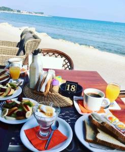 a table with a breakfast of eggs and toast on the beach at Ninos On The Beach Hotel in Roda