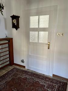 una puerta blanca con una ventana y un reloj en Apartmán Colette, en Praga