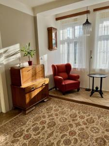 a living room with a red chair and a table at Apartmán Colette in Prague