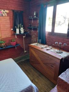 a bedroom with a bed and a dresser and a window at La Estancia hostel in Colonia del Sacramento