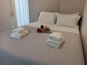 a bed with towels and a tray of food on it at Central Fountain in Asprovalta