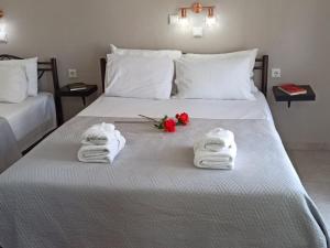 a hotel room with towels and roses on a bed at Central Fountain in Asprovalta