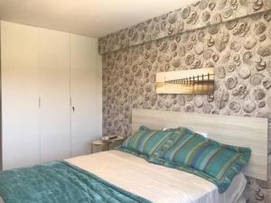 a bedroom with a bed and a wall at Apt. 305 Bloco 7 · Flat com 2 quartos no La Fleur Polinésia - Muro Alto in Porto De Galinhas