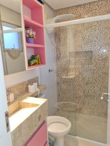 a bathroom with a toilet and a glass shower at COBERTURA VISTA PARA MAR - WI-FI, PISCINA, AR - Disponível Páscoa - 29-03 in Bertioga