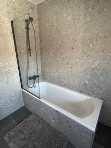 a bath tub in a bathroom with a glass wall at A la Vida in Bruges +7 photos