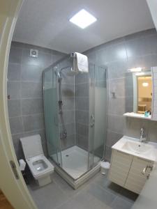 ein Bad mit einer Dusche, einem WC und einem Waschbecken in der Unterkunft Yakamoz Otel in Urla