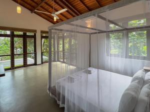 Habitación con una mesa blanca con paredes de cristal. en Villa Ema, en Galle