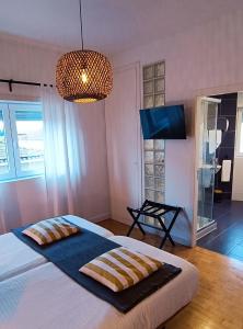 1 dormitorio con 1 cama con 2 almohadas en Aveiro Rossio Lodge, en Aveiro