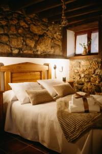 a bedroom with a large bed in a stone wall at Apartamentos Rurales La Casina del Fontan in Valle de Lago