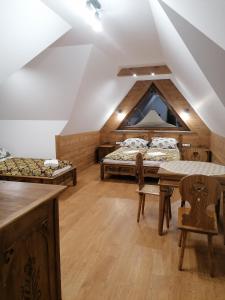 Zimmer im Dachgeschoss mit 2 Betten, einem Tisch und Stühlen in der Unterkunft Białczańska Ostoja in Białka Tatrzańska
