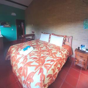a bedroom with a large bed with a colorful blanket at Espaço Puri in Divino de São Lourenço