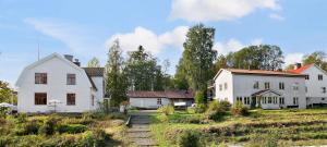 una casa blanca y dos casas blancas en un campo en Sågverket Höga Kusten, en Rö