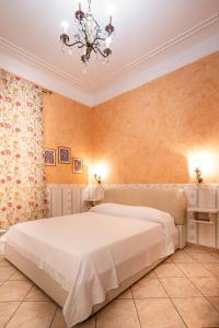 a bedroom with a large bed and a chandelier at Affittacamere Guest House Glatimia in Rome