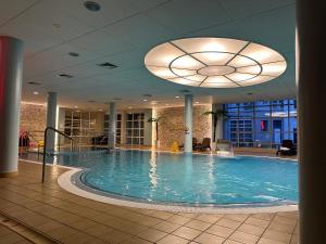 - une grande piscine dans un bâtiment doté d'un plafond dans l'établissement Apartament 454 w hotelu Diva, à Kołobrzeg