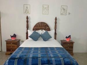 a bedroom with a bed with blue and white pillows at GraceWay Studio Apt with A/C -3mins walk to beach in Negril