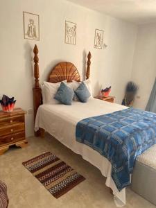 a bedroom with a large bed with a blue blanket at GraceWay Studio Apt with A/C -3mins walk to beach in Negril