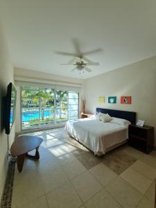 um quarto com uma cama e uma ventoinha de tecto em Lujoso Departamento en Acapulco con Alberca y club de Playa em Acapulco
