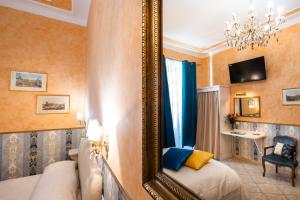 a mirror in a room with a bed and a chair at Affittacamere Guest House Glatimia in Rome