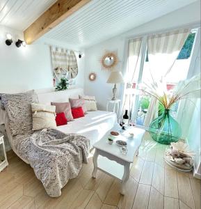ein Wohnzimmer mit einem weißen Sofa und einem Tisch in der Unterkunft Casa Luciana in Saint-Priest