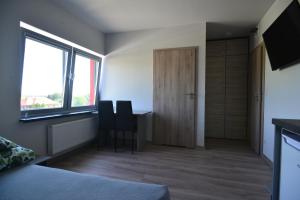 een slaapkamer met een bureau, 2 stoelen en een raam bij Noclegi URAN in Sufczyn