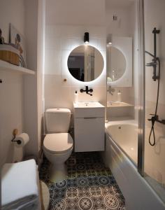 a bathroom with a toilet and a sink and a tub at Spacious, quiet and bright apartment, close to the center - free parking in Warsaw