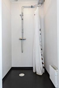 y baño con ducha y cortina de ducha. en Sågverket Höga Kusten en Rö