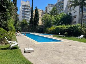 una persona sentada en una silla junto a una piscina en Palermo Soho. 3 ambientes con piscina y cochera, en Buenos Aires