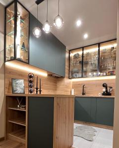 波羅維茨的住宿－The Green apartment，厨房配有绿色橱柜和带酒杯的吧台