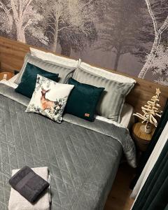 un letto con cuscini verdi e bianchi di The Green apartment a Borovets
