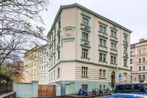 a white building with a statue on the side of it at Alla Prague Apartment in Prague