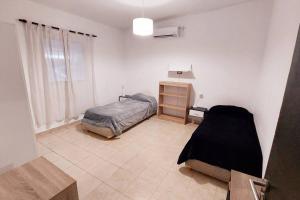 a bedroom with a bed and a dresser in it at Casa Familiar in La Rioja