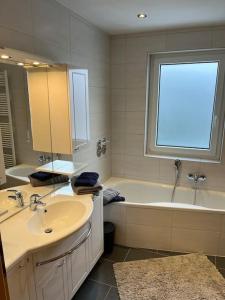 bagno con lavandino, vasca e finestra di Ferienwohnung in ruhiger Lage a Thurnau