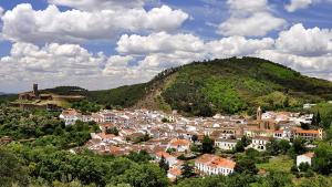 una pequeña ciudad frente a una colina verde en Rincón EL ENCANTO de Aracena, en Aracena