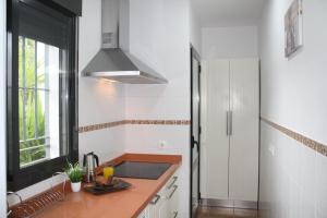 eine Küche mit einer Theke, einem Waschbecken und einem Fenster in der Unterkunft Rincón EL ENCANTO de Aracena in Aracena