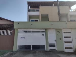 a pair of garage doors in front of a building at Triplex 3 quartos a 100 metros de Costa Azul in Rio das Ostras