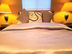 a bedroom with a large bed with two lamps at White Sands Oasis in Alamogordo