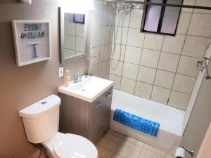 a bathroom with a toilet and a sink and a shower at White Sands Oasis in Alamogordo