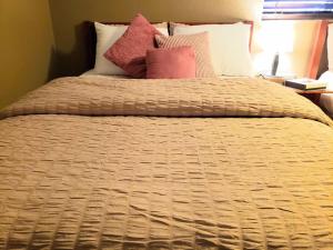 una cama con varias almohadas encima en White Sands Oasis en Alamogordo