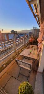 un balcone con tavoli e panche in legno su un edificio di The Beautiful Bankmore Penthouse a Belfast