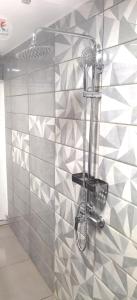 a shower in a bathroom with a tiled wall at DV Real Philoxénia in Saint Martin