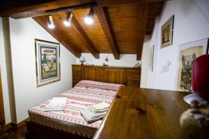 Maison La Bagne في أَويستا: غرفة نوم بسرير وطاولة خشبية