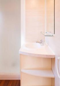 a white bathroom with a sink and a mirror at Camping Valencia el Saler in El Saler