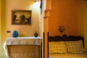 a bedroom with a bed and a table and a painting at Alf Leila Boutique Hotel in Dahab